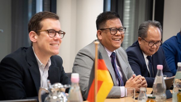 Ben Brake and Ichwan Nasution sitting next to each other and smiling