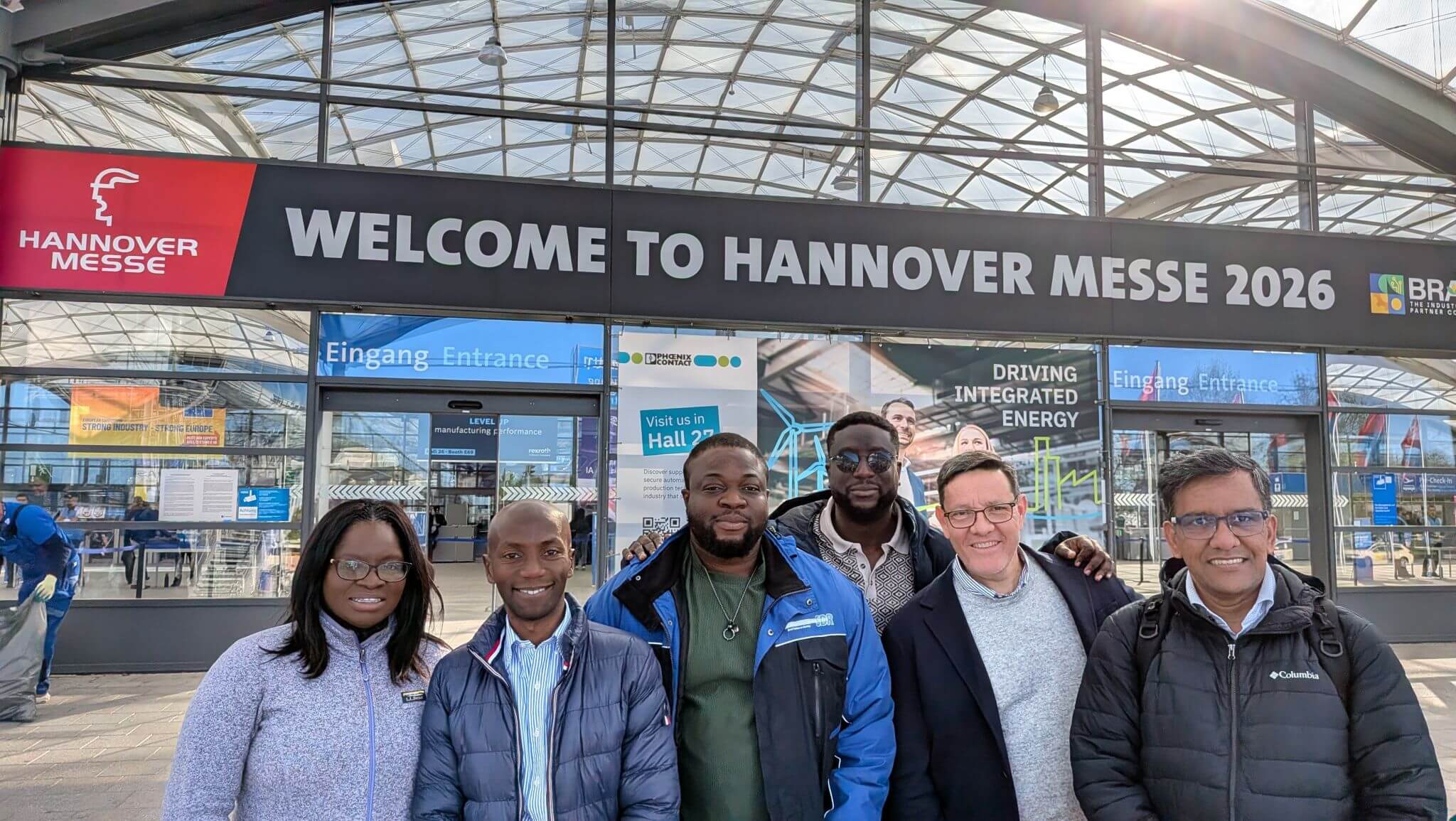 Mitglieder einer internationalen Delegation posieren vor dem Haupteingang der Hannover Messe 2026.